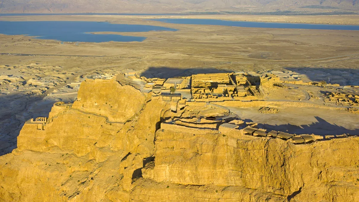 Herod's Northern Palace on the cliff edge of Masada, with the Dead Sea behind, masada and dead sea tour from jerusalem